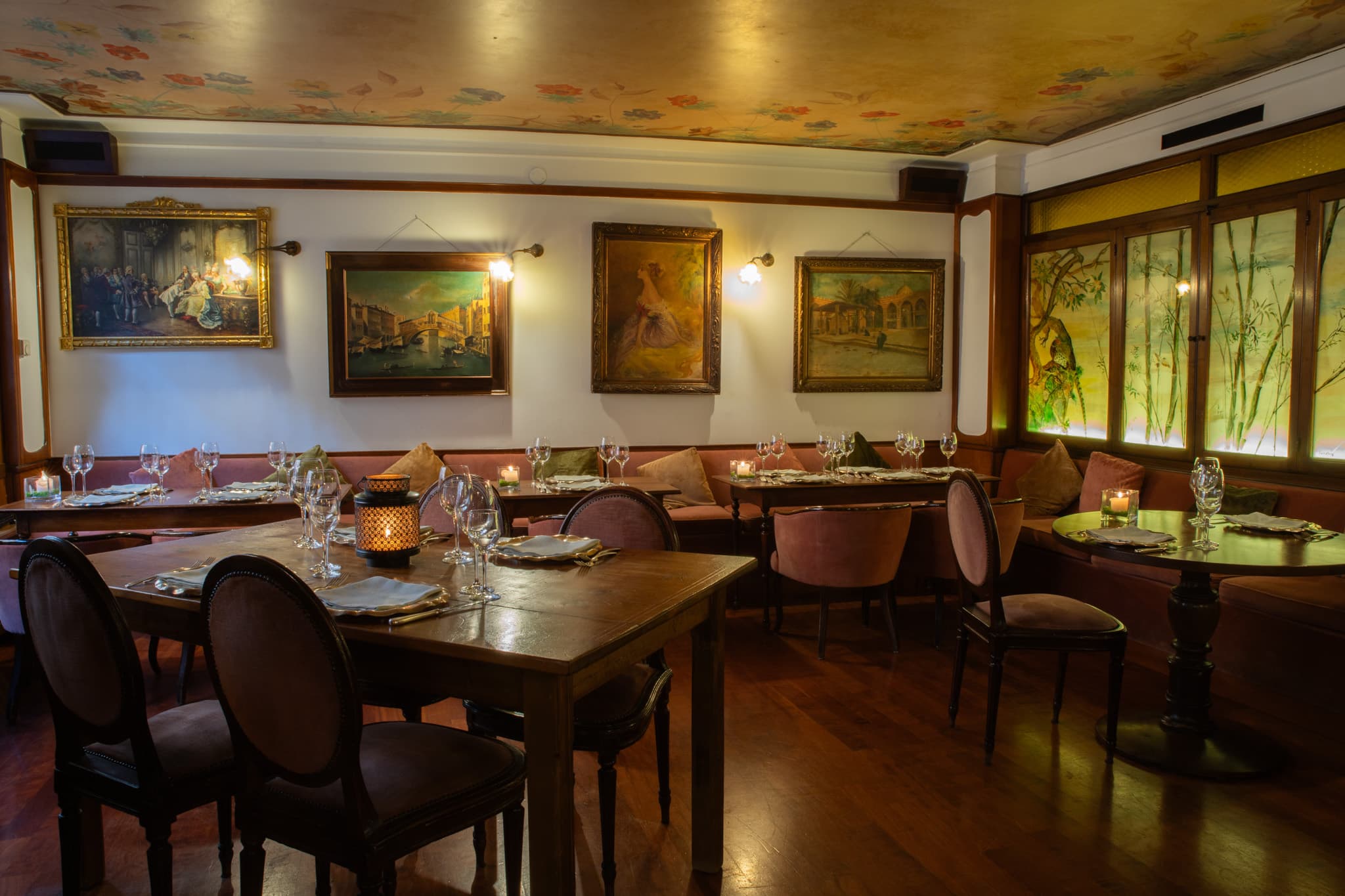 Sala del ristorante con quadri alle pareti e tavoli apparecchiati